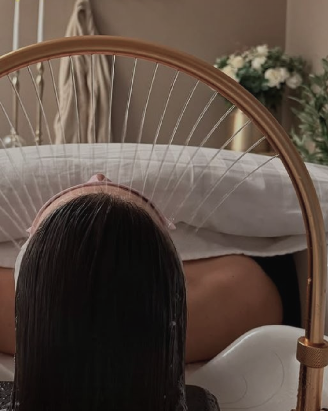 en headspa behandling genomförs där en kund ligger avslappnad under rinnande vatten över håret