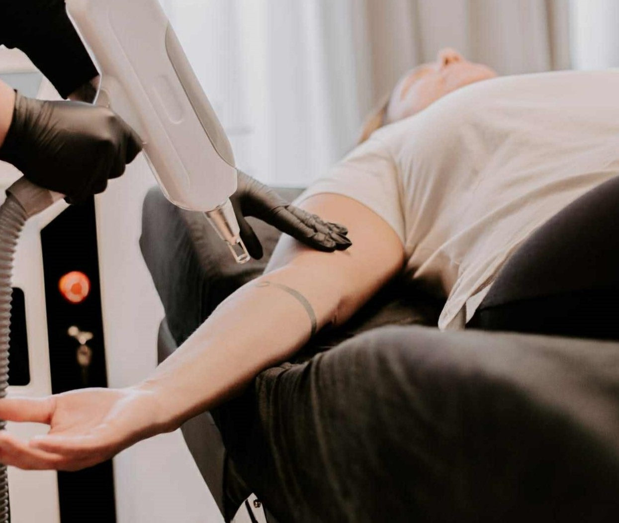 en kund genomgår en behandling av tatueringsborttagning med laser.