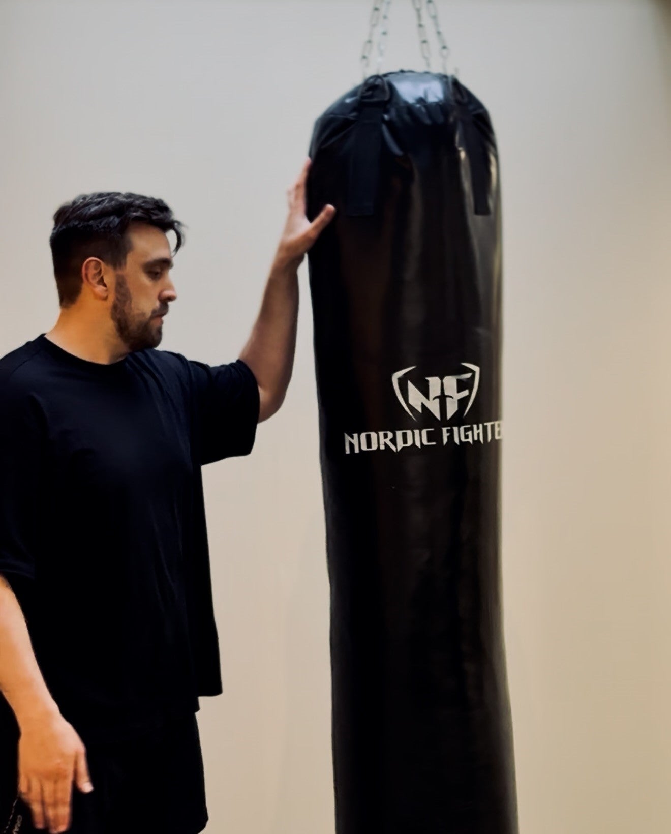 personliga tränaren johan poserar vid boxingssäck